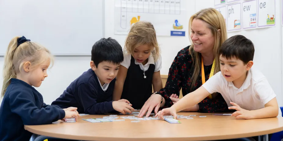 A teaching assistant working with a group of children