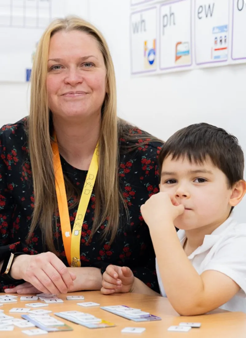 A teaching assistant does a one-to-one intervention with a pupil